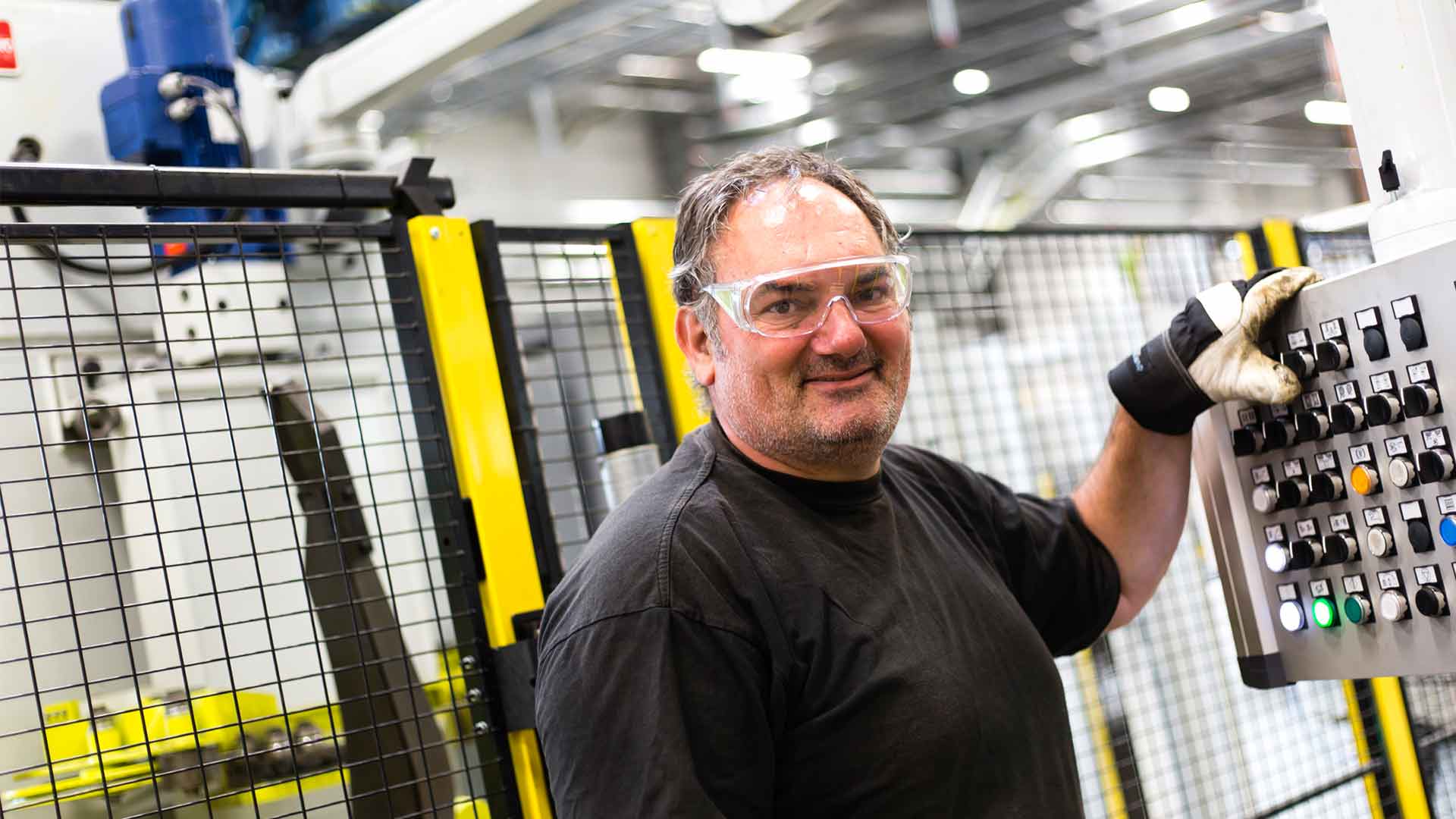 Man manövrerar maskinpanel framför Axelents maskinskydd