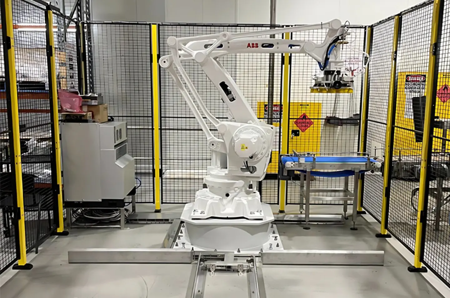 Industriell robotpalleterare och depalleterare som hanterar varor på transportbandslinje