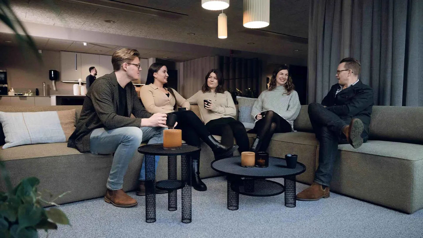Två män och tre kvinnor sitter i en soffa och pratar