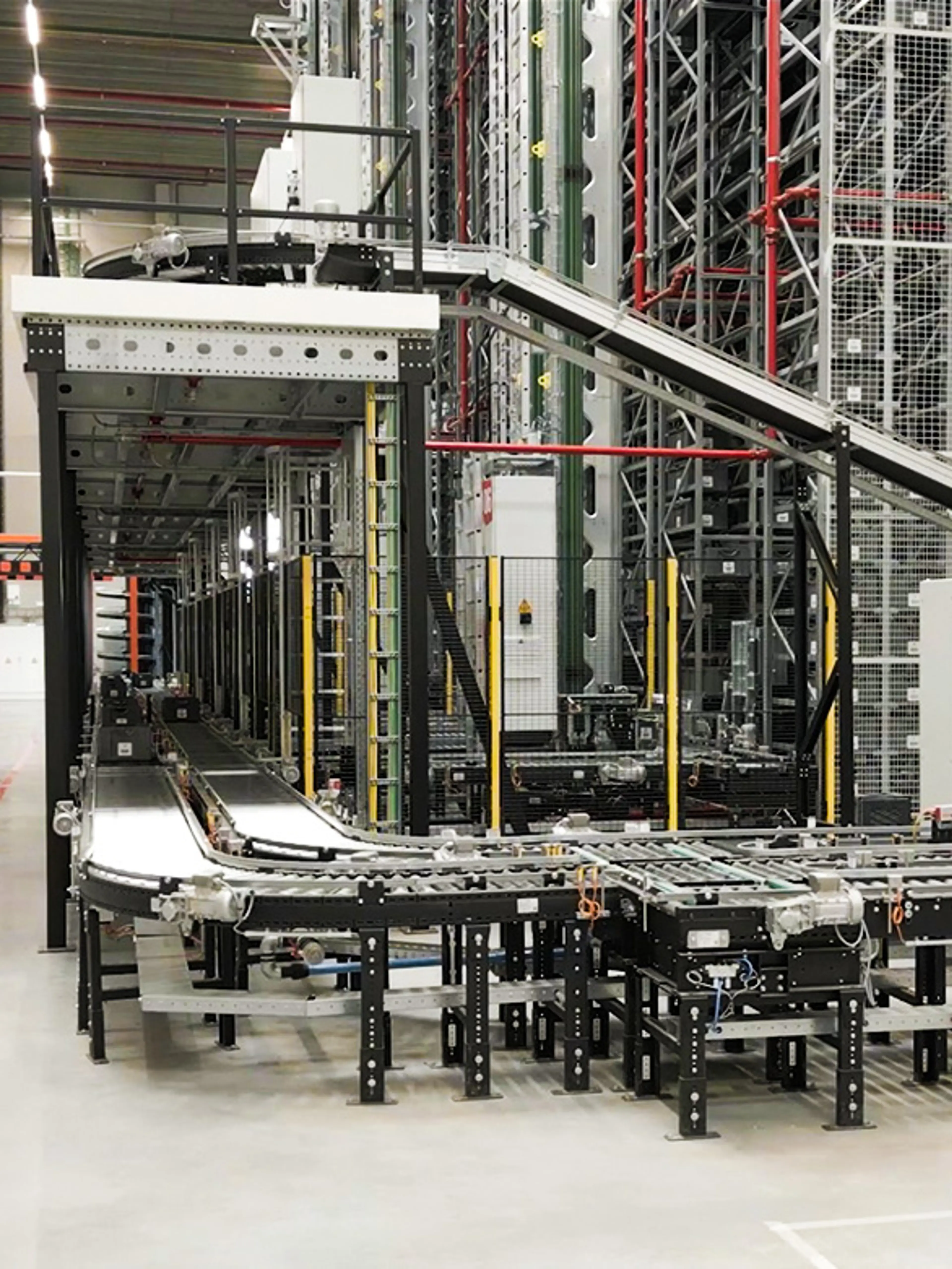 Automatiserat rull- och bandtransportsystem i ett lager, används för transport av korgar och lådor