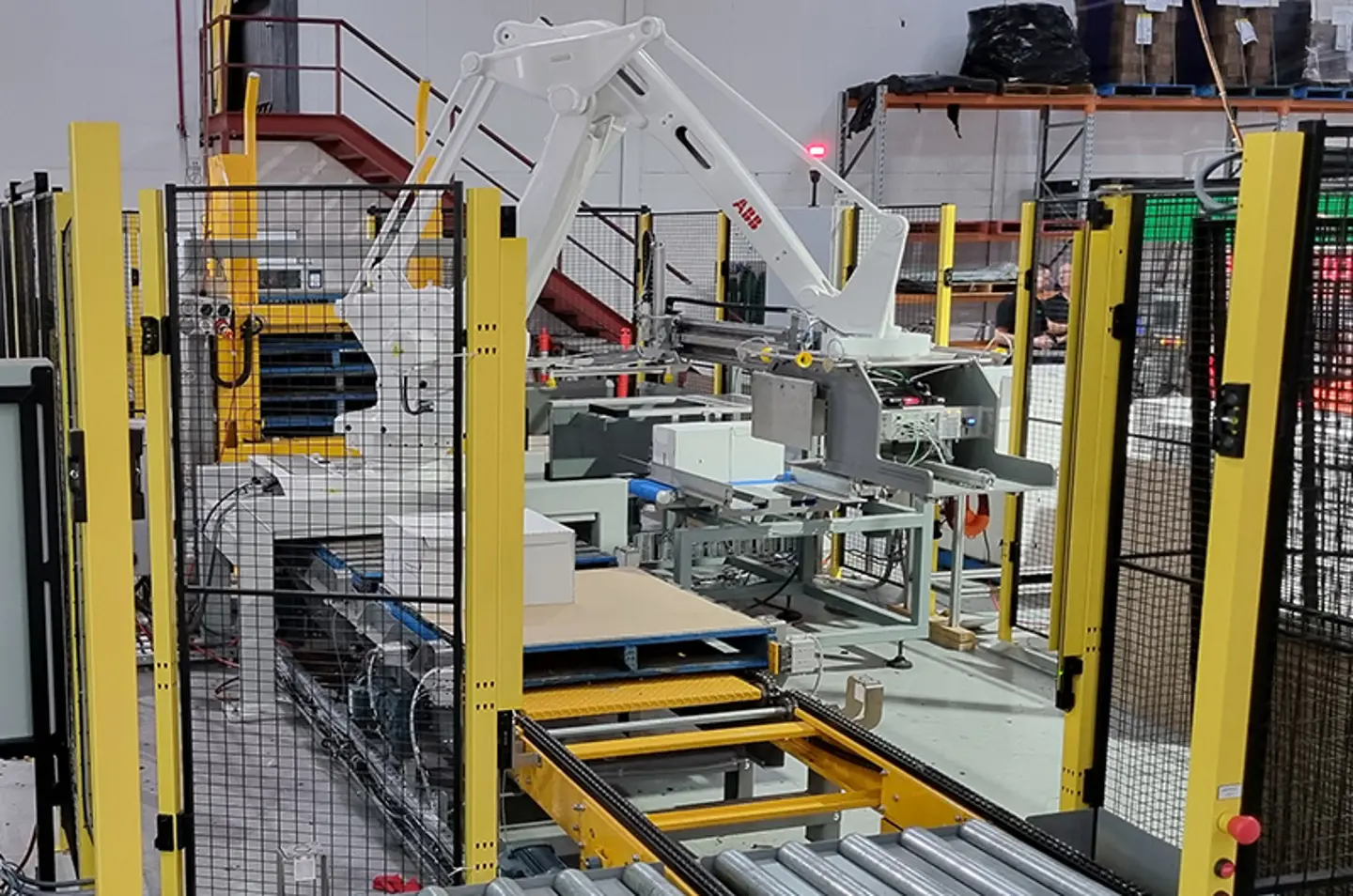 Robotiserad palleterare staplar stora säckar med maskinskydd för operatörens säkerhet